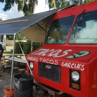 a man standing in front of a taco truck