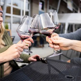 a group of people clinking wine glasses