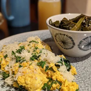 a plate of scrambled eggs and greens