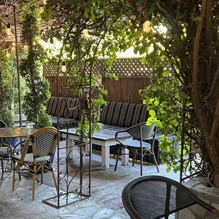 The outdoor seating area which is completely covered by foliage.