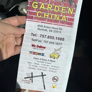 a person holding up a menu