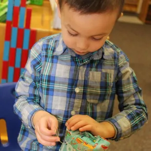 Yes, he's sewing a little pillow!  They learn practical life skills as well as subject matter like geography and fractions!