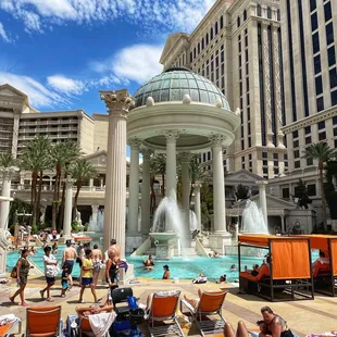 a fountain with fountains and lounge chairs