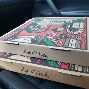 two pizza boxes in the back of a car