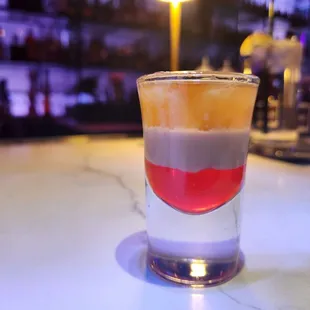 a shot of a colorful drink on a table
