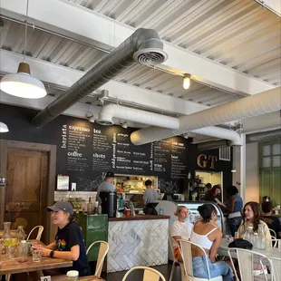 people sitting at tables in a cafe