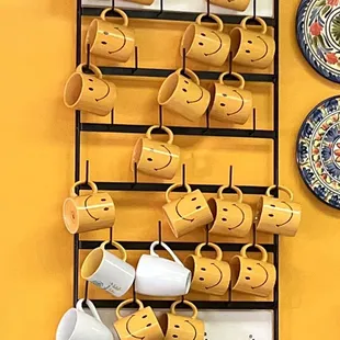 a rack of coffee cups with smiley faces
