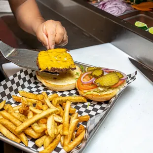 a person serving a burger and fries