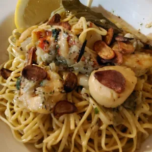 Lobster, scallops, and shrimp with onions and caramelized garlic on linguini.
