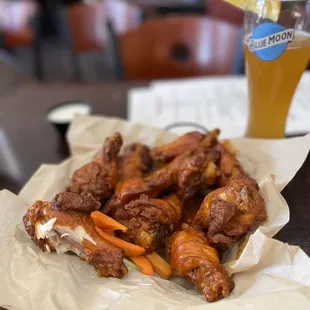 a plate of chicken wings and a glass of beer
