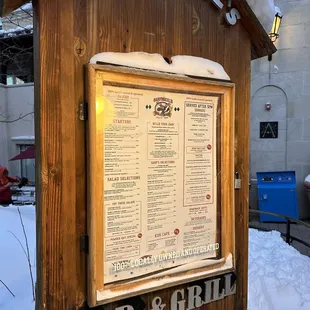a wooden sign in the snow