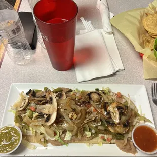 Vegan Huarache - freshly made corn tortilla topped with refried beans and lots of vegetables. Delicious