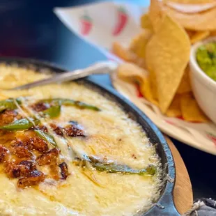 a bowl of guacamole and a plate of chips