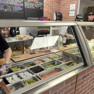 a man standing in front of a deli counter