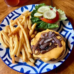 a burger and fries on a blue and white plate