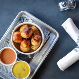 a tray of pastries and dipping sauces