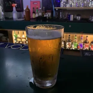 a glass of beer on a bar