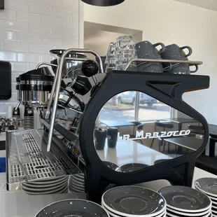 a coffee machine and cups on a counter