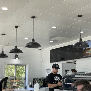 a man standing at the counter of a coffee shop