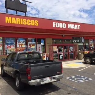 a black pickup truck parked in front of a restaurant