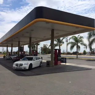 a white car parked in front of a gas station