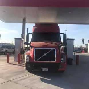 a red semi truck at a gas station