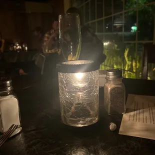 a glass of water with a candle in it
