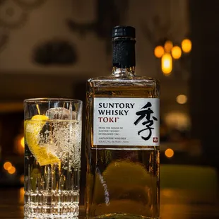 a bottle of suntory whisky and a glass of water
