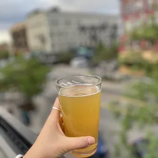 a person holding a glass of beer