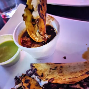 a hand dipping a tortilla