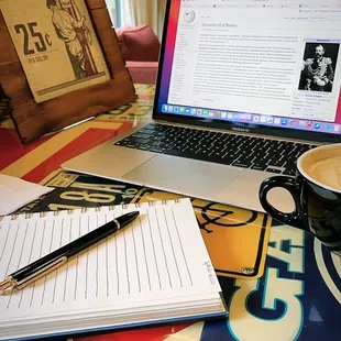 a cup of coffee and a notebook on a table