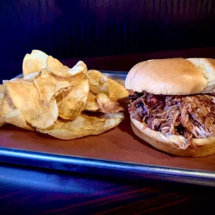 a pulled pork sandwich and chips