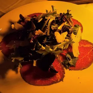 Carpaccio: thin slices of filet mignon, mixed greens, shaved parmesan cheese, olive oil
