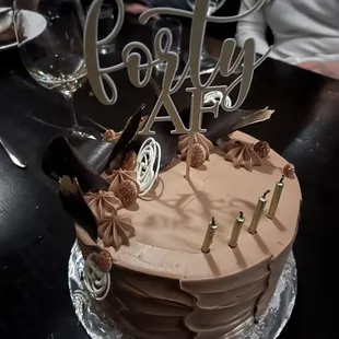 Chocolate cake with cookies and cream filling, chocolate buttercream and chocolate curls with gold glitter.