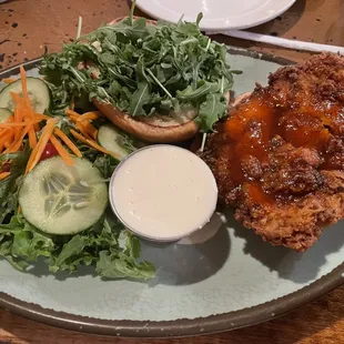 Sweet spicy chicken sandwich with side salad and blue cheese dressing.