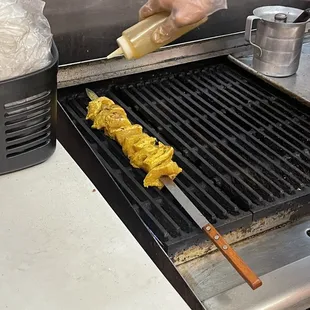 a person preparing food on a grill