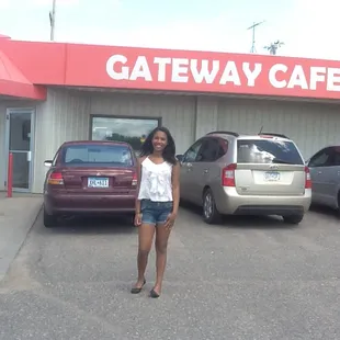 a woman standing in front of a cafe