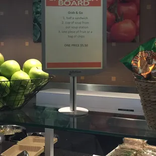 a sandwich board and a basket of apples