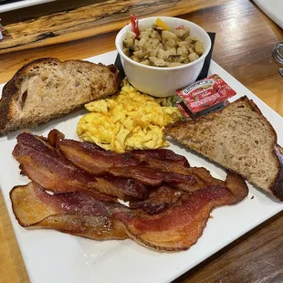 a plate of bacon, eggs, and toast