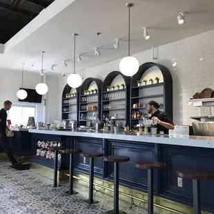 two people standing at a counter in a restaurant