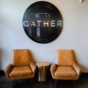 two leather chairs in front of a sign