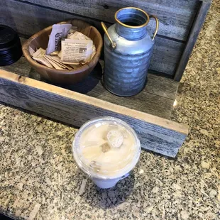 a cup of coffee and a container of cookies