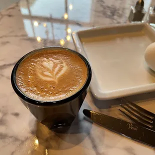 a cup of cappuccino on a marble table