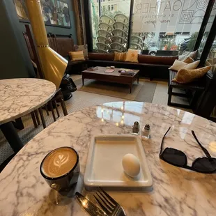 a table with a plate of food and a cup of coffee