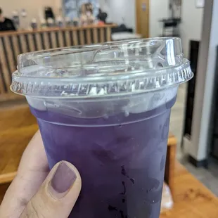 a hand holding a purple drink