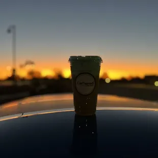 a cup of coffee on top of a car