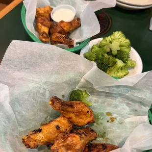 a plate of chicken wings and broccoli