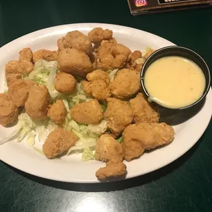 a white plate with a salad and dipping sauce