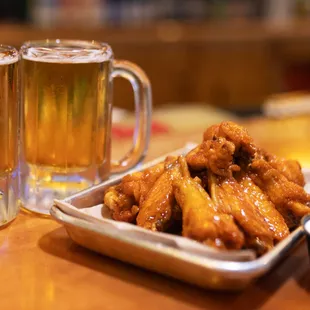 a glass of beer and a plate of chicken wings