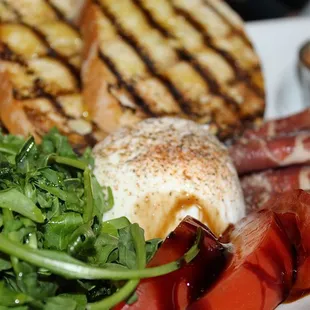 The Burrata E Prosciutto was made with  grilled ciabatta, prosciutto, tomato, tomato jam, and arugula.